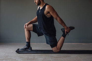 A man doing a lunge variation stretch for balance, mobility, and flexibility.