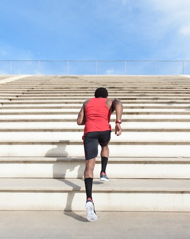 A man running stairs in a cardio workout outside.
