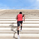 A man running stairs in a cardio workout outside.