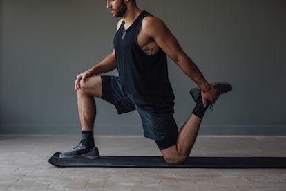A man doing a lunge variation stretch.