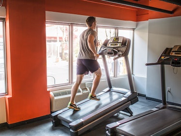 A man doing the 12-3-30 workout on a treadmill in a gym.