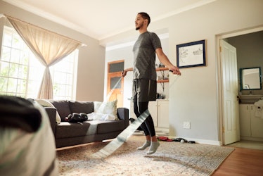 A man jumping rope at home in the living room.