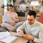Couple sitting in their living room and checking their finances