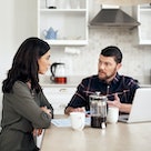 Man and woman sitting at breakfast table having serious conversation