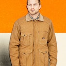 man wearing the Patagonia Iron Forge Hemp Canvas Barn Coat in front of an orange and white backgroun...